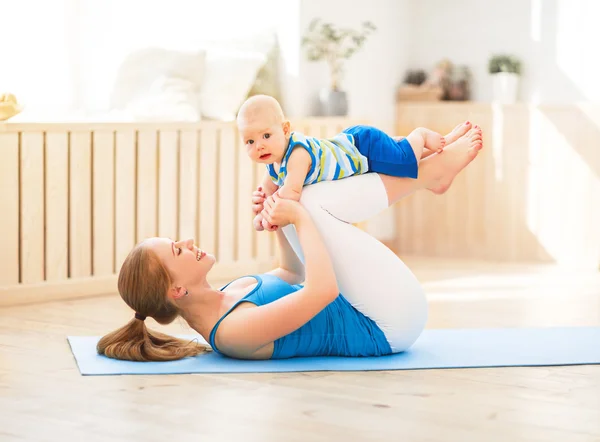 Madre de deportes se dedica a la aptitud y el yoga con el bebé en casa — Foto de Stock