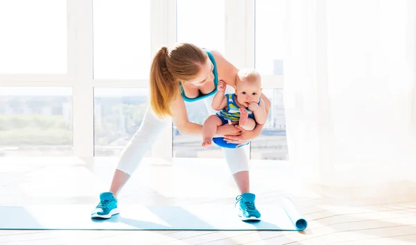 Esportes mãe está envolvida em fitness e ioga com o bebê em casa — Fotografia de Stock