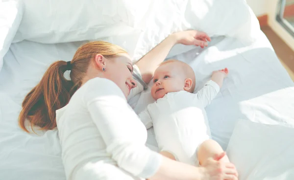 Boldog család, anya, baba, játék, és ölelés az ágyban — Stock Fotó