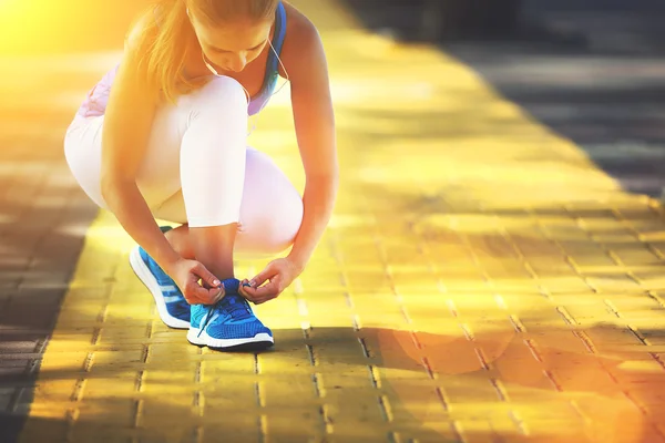 Woman athlete runner run and tying shoelaces — Stock Photo, Image