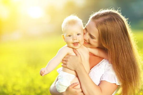 Feliz familia madre y bebé abrazando y riendo en verano en n — Foto de Stock