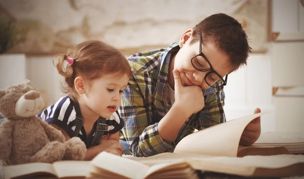 Children brother and sister, boy and girl reading a book — Stock Photo, Image