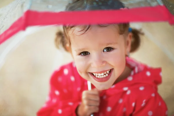 Yağmurda bir şemsiye ile gülen kız mutlu çocuk — Stok fotoğraf