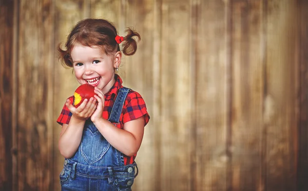 Glad flicka äter mogen persika — Stockfoto