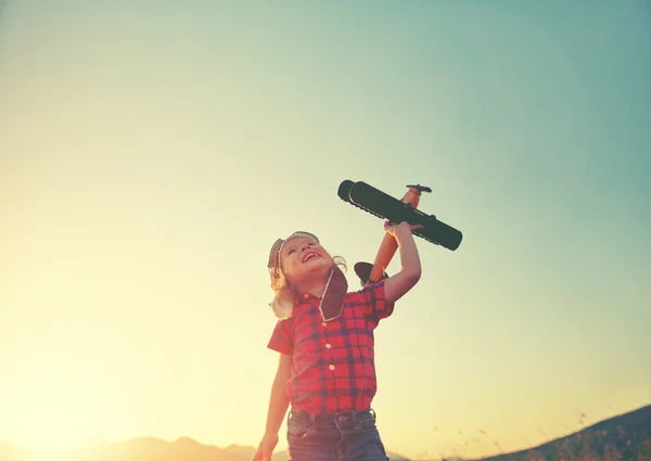 Happy child dreams of traveling and playing with an airplane pil — Stock Photo, Image