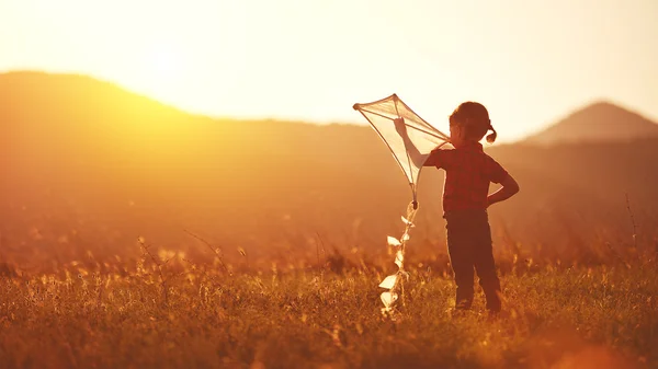 Glückliches Kindermädchen mit Drachen auf der Wiese im Sommer — Stockfoto