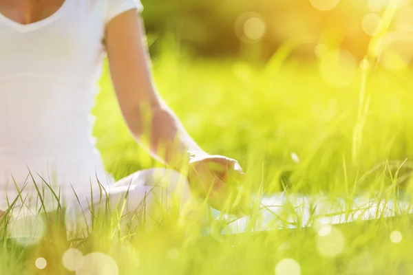 Hand av kvinna mediterar i lotusställning utövar yoga — Stockfoto