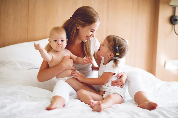 Feliz familia madre y dos hijos, hijo e hija en la cama —  Fotos de Stock