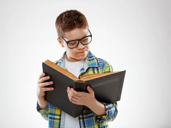Niño niño adolescente con gafas reding libro sobre fondo gris —  Fotos de Stock