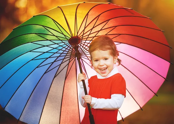 Niña feliz con paraguas de arco iris multicolor en pa —  Fotos de Stock