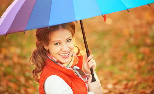 Happy woman with rainbow multicolored umbrella under rain in par — Stock Photo, Image
