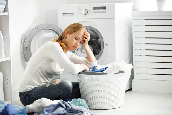 Fáradt boldogtalan nő háziasszony fold ruhákat a mosás Mac — Stock Fotó