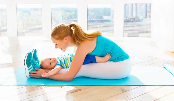 Madre de deportes se dedica a la aptitud y el yoga con el bebé en casa — Foto de Stock