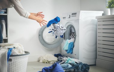 Çamaşırhane kavramı. kirli giysilerini sinekler çamaşır makinesi içine