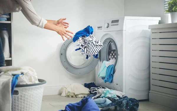 Wäschekonzept. Schmutzige Wäsche fliegt in Waschmaschine — Stockfoto