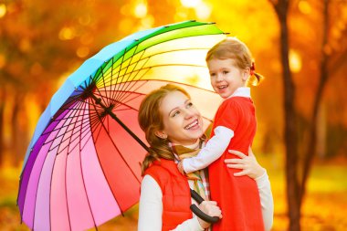 Umbrell mutlu aile anne ve çocuk kızı ile gökkuşağı renkli