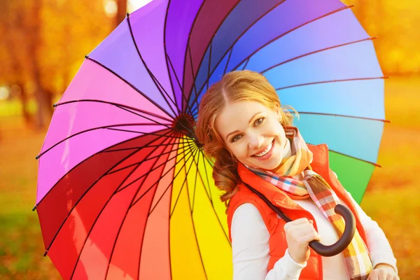 Wanita bahagia dengan pelangi dikalikan payung di bawah hujan dalam par — Stok Foto