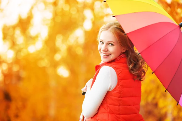 Mulher feliz com arco-íris guarda-chuva multicolorido sob a chuva em par — Fotografia de Stock