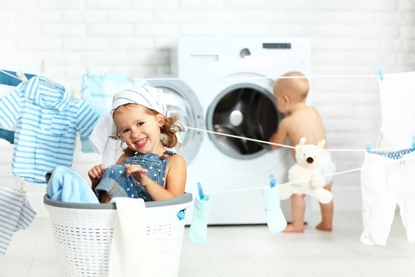 Pequeños ayudantes divertidos niños feliz hermana y hermano en la lavandería a — Foto de Stock