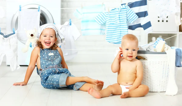 Pequeños ayudantes divertidos niños feliz hermana y hermano en la lavandería a —  Fotos de Stock