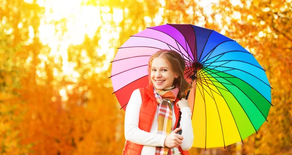 Mujer feliz con paraguas multicolor arco iris bajo la lluvia a la par —  Fotos de Stock