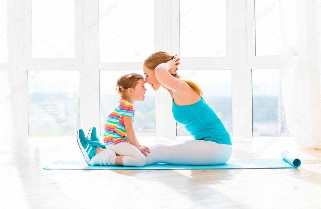 family mother and child daughter are engaged in fitness, yoga at