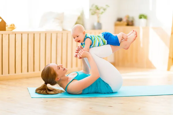 Madre sportiva è impegnata in fitness e yoga con il bambino a casa — Foto Stock