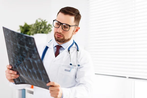 Ärztin untersucht Röntgenbild in ihrem Büro — Stockfoto