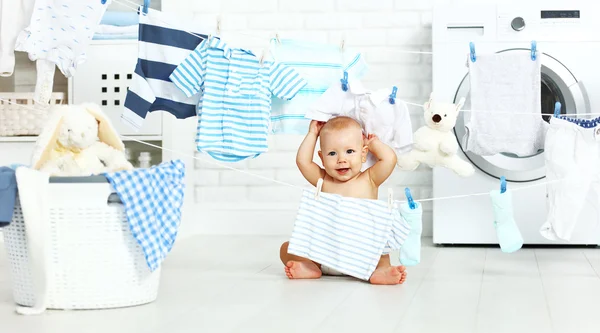 Divertido bebé feliz niño para lavar la ropa y se ríe en la lavandería —  Fotos de Stock