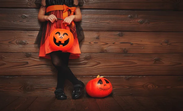 Gambe di bambina in costume da strega per Halloween con zucca — Foto Stock