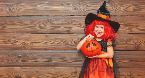 Funny dítě dívka v čarodějnice kostým pro Halloween dýně ja — Stock fotografie