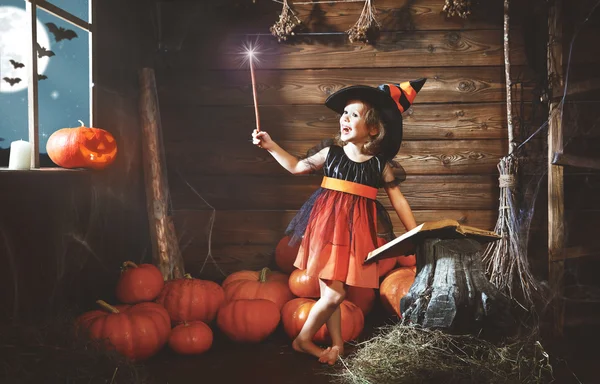 Halloween. dítě malá čarodějnice s kouzelnou hůlkou a čtení mag — Stock fotografie