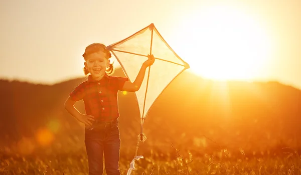 Happy child girl with a kite on meadow in summer — Stock Photo, Image