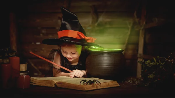 Halloween. Hexenkind bereitet Zaubertrank im Hexenkessel zu — Stockfoto