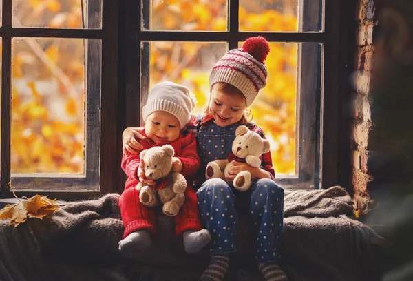 Crianças felizes irmão e irmã jogando perto da janela cair — Fotografia de Stock