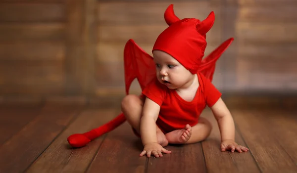 Funny baby in devil halloween costume on wooden background — Stock Photo, Image