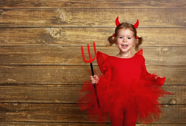 Divertida niña en traje de Halloween diablo en la espalda de madera oscura —  Fotos de Stock