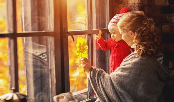 Happy family mother and baby playing and laughing at window in f — Stock Photo, Image