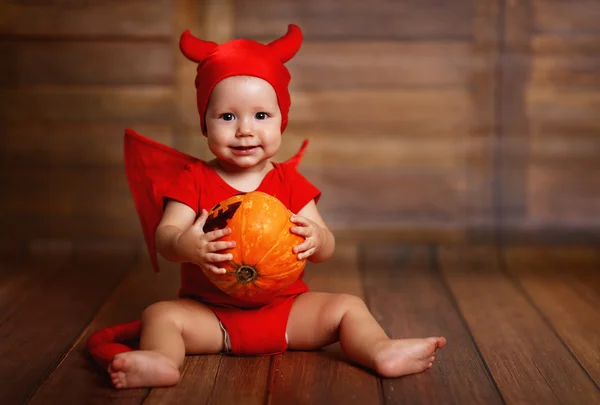 Divertido bebé en traje de Halloween diablo con calabaza —  Fotos de Stock