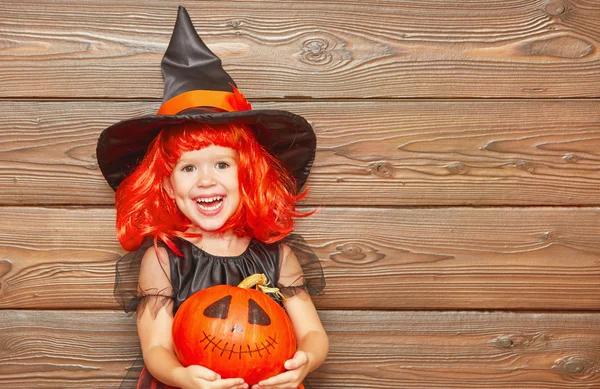 Divertida niña en traje de bruja para Halloween con calabaza Ja —  Fotos de Stock