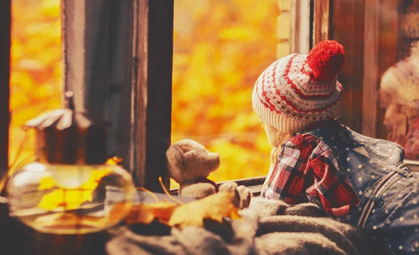 Kindermädchen blickt durch offenes Fenster auf den Herbst der Natur — Stockfoto