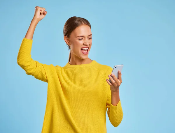 Szczęśliwa Ekspresyjna Kobieta Żółtym Swetrze Smartfonem Krzyczy Świętując Sukces Zwycięstwa — Zdjęcie stockowe