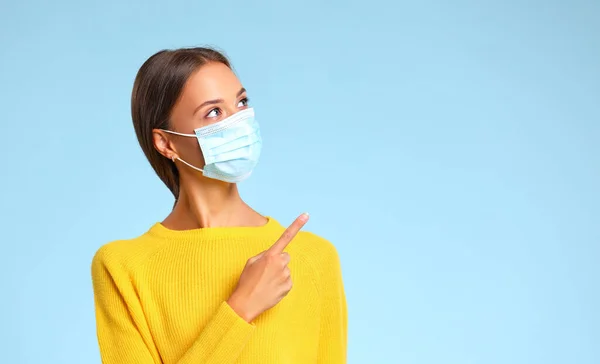 코로나 바이러스가 유행하는 어깨너머 공간을 가리키는 의료용 마스크를 파란색 대퇴골에 — 스톡 사진