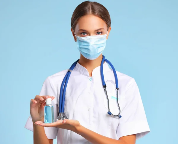 Mulher Uniforme Médico Máscara Demonstrando Frasco Desinfetante Durante Pandemia Coronavírus — Fotografia de Stock