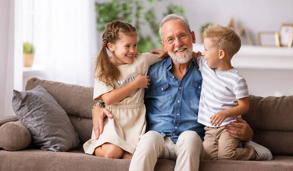 Fröhlich Gealterter Mann Lächelt Und Umarmt Süße Jungen Und Mädchen — Stockfoto