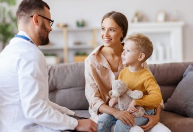  Dost canlısı bir çocuk doktoru aile doktorunun resepsiyonunda annesiyle birlikte mutlu bir çocuk hasta.