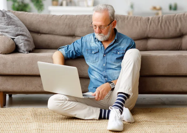 Baard Oudere Man Ontspannen Vloer Buurt Van Bank Browsen Laptop — Stockfoto
