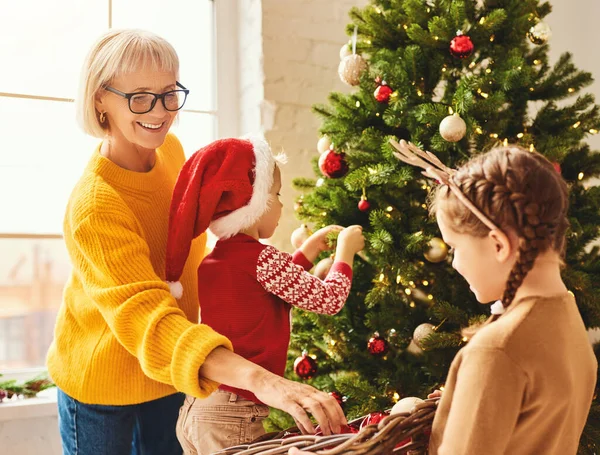 Vrolijke Volwassen Vrouw Schattige Kinderen Versieren Naaldboom Met Diverse Kerstballen — Stockfoto