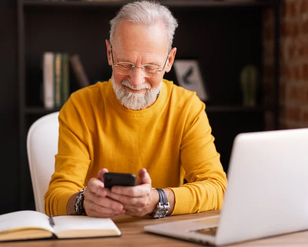 Stijlvolle Oudere Man Glimlachend Maakt Gebruik Van Een Smartphone Tijdens — Stockfoto