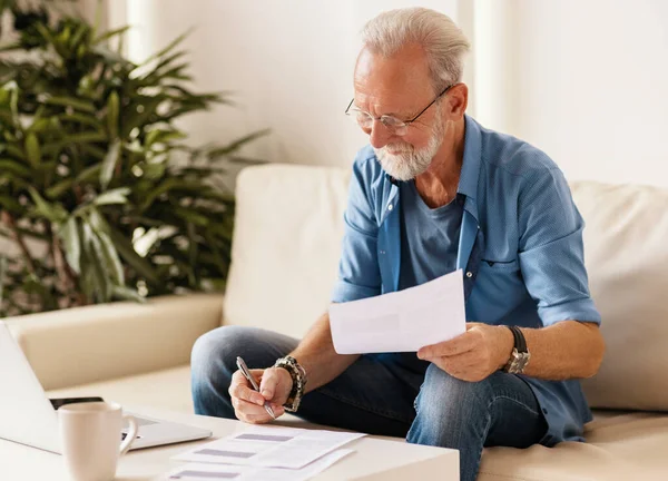 Hombre Edad Positiva Gafas Leyendo Llenando Documentos Mientras Está Sentado —  Fotos de Stock